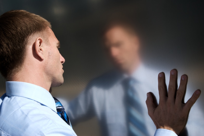 Professional looking male staring at his own blurry reflection