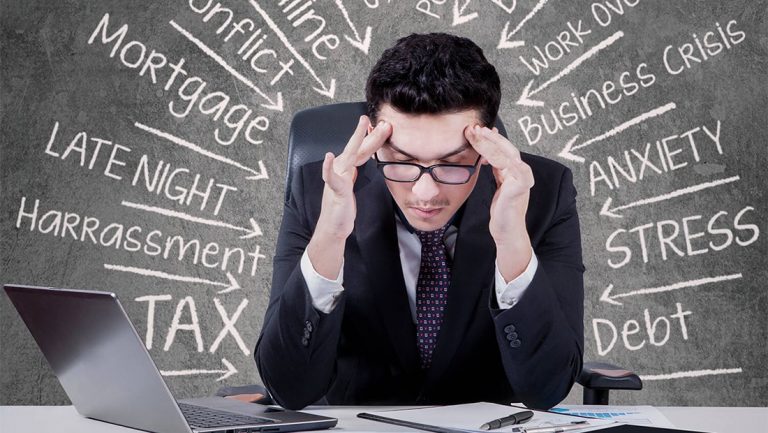 man in suit stressed over work1 1 1 - Overcoming Burnout: Causes, Signs, Symptoms & How to Fight it