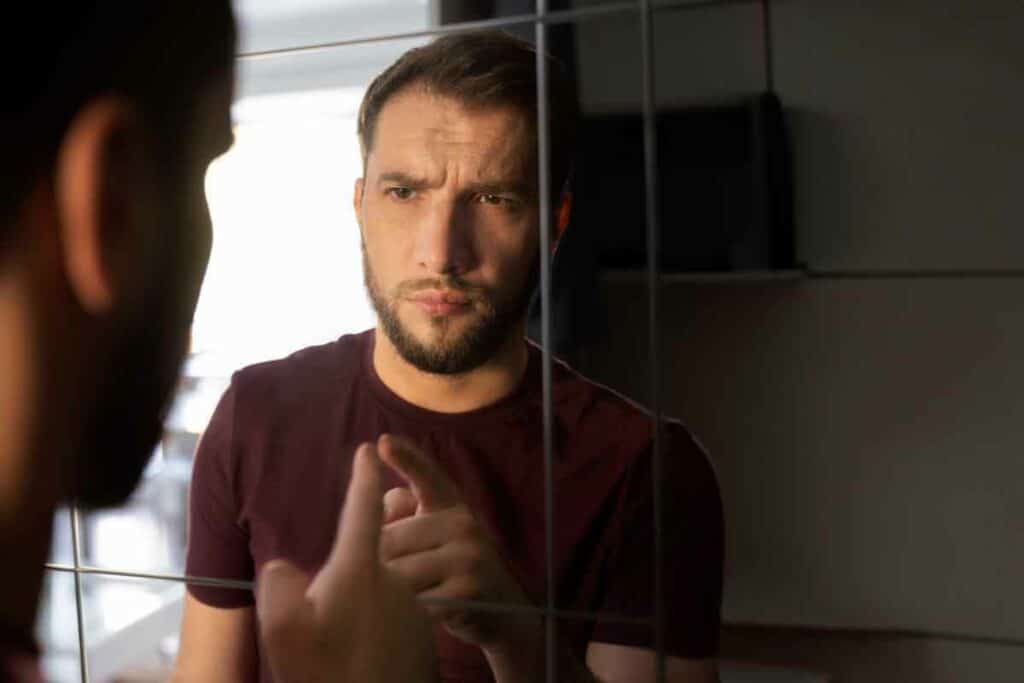 anxious man looking mirror talking to himself