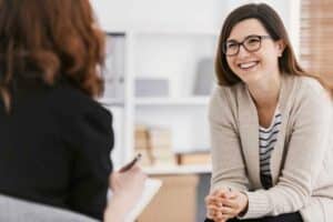 Happy woman during successful psychotherapy with counsellor