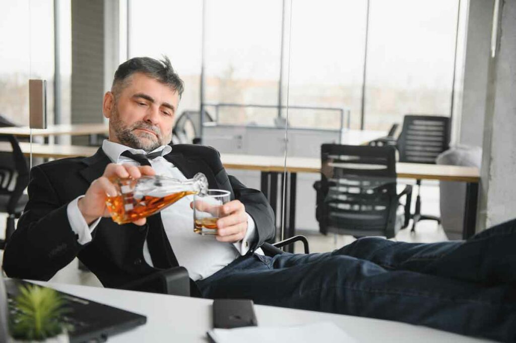old businessman drinking from stress, sign of alcoholism, workaholism