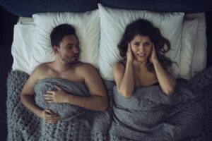 Woman laying on bed with partner- The Dawn blog post image