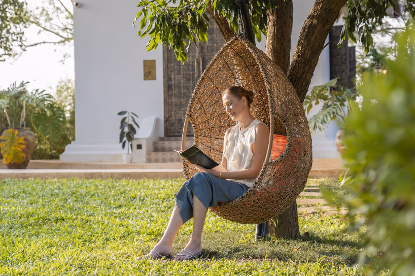 female client on wicker hanging chair - Why Choose Us
